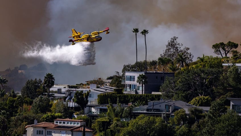 plane drops water on wildfire in California