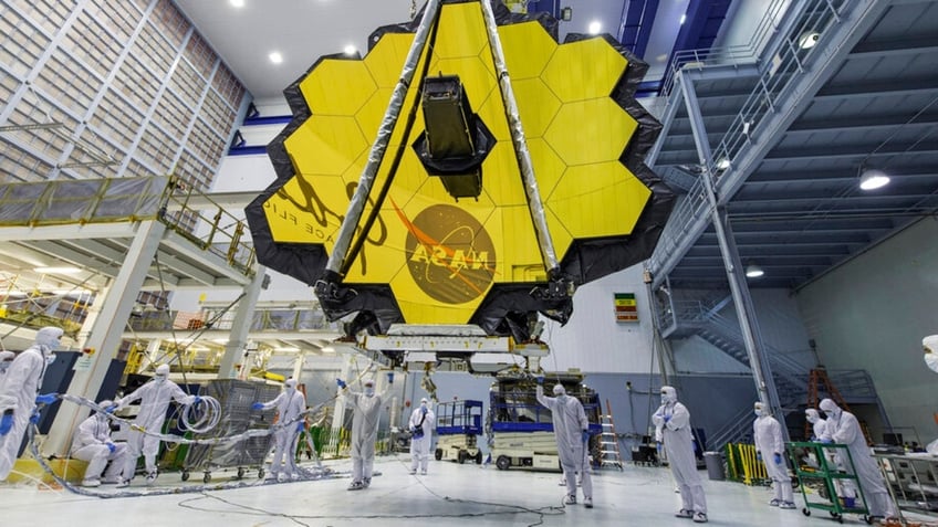 Technicians lift the mirror of the James Webb Space Telescope