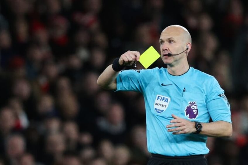 Premier League referee Anthony Taylor shows a yellow card