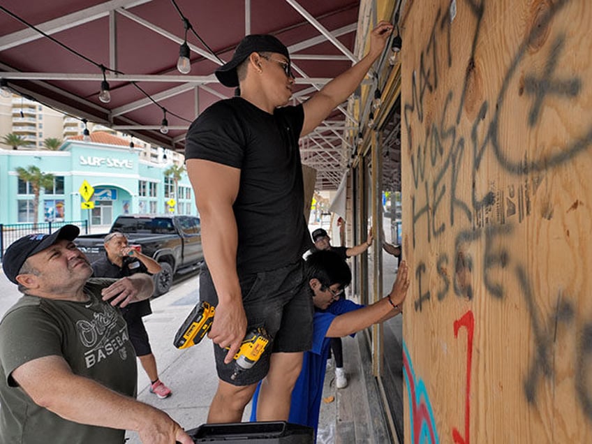 Workers outside Toucans Bar and Grill board up the restaurant Monday, Oct. 7, 2024, in Cle