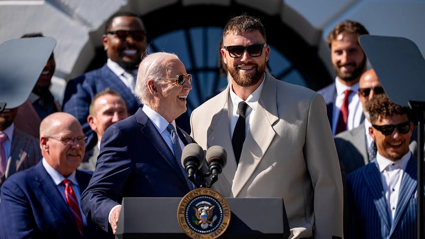 Joe Biden stands next to Travis Kelce