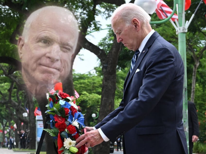 president joe biden kisses john mccains memorial in vietnam