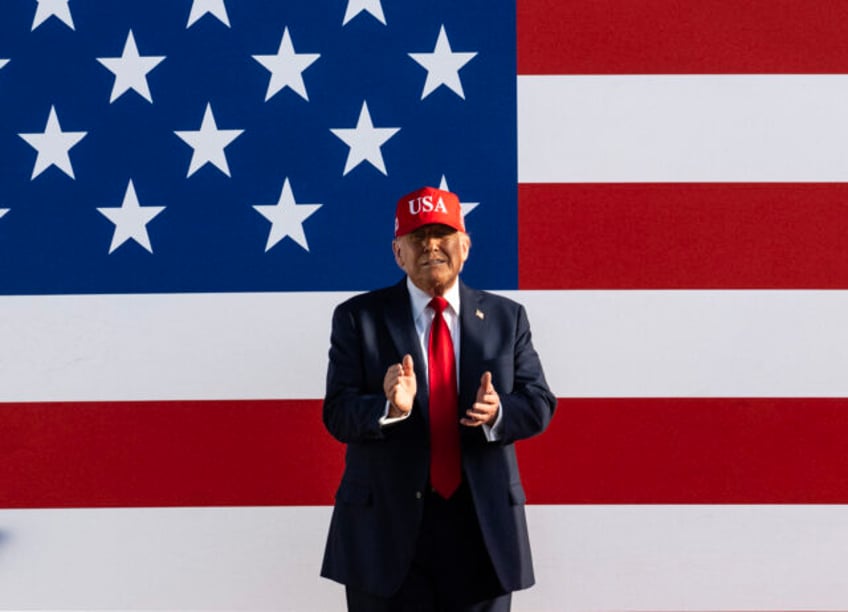 TOPSHOT - US President Donald Trump claps as he arrives to speak at the Salute to America