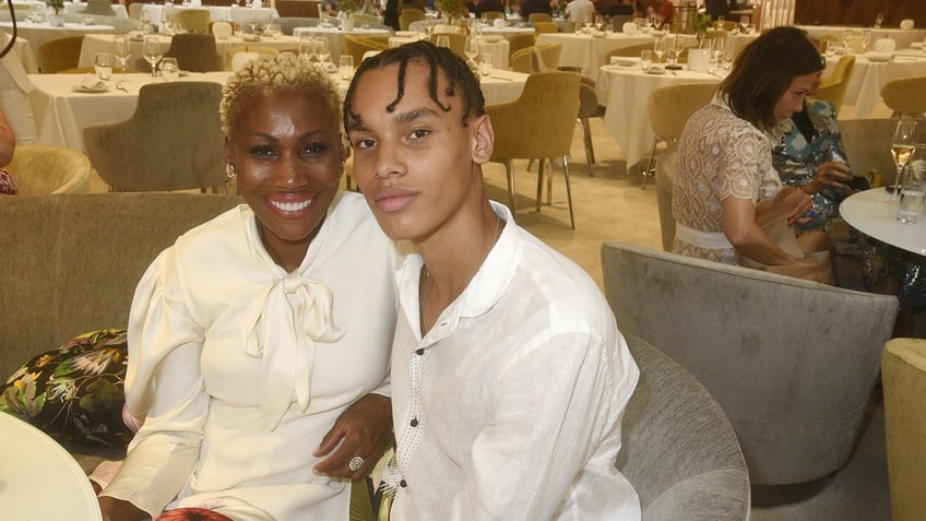 Nicole Coste wearing white and sitting down with her son Alexandre