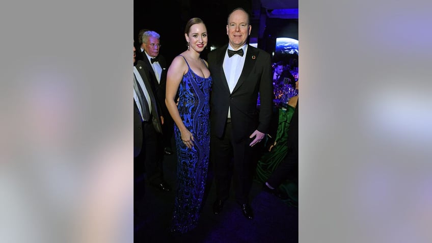 Jazmin Grimaldi wearing a blue and black spaghetti strap dress with her father Prince Albert of Monaco wearing a suit and bow tie.