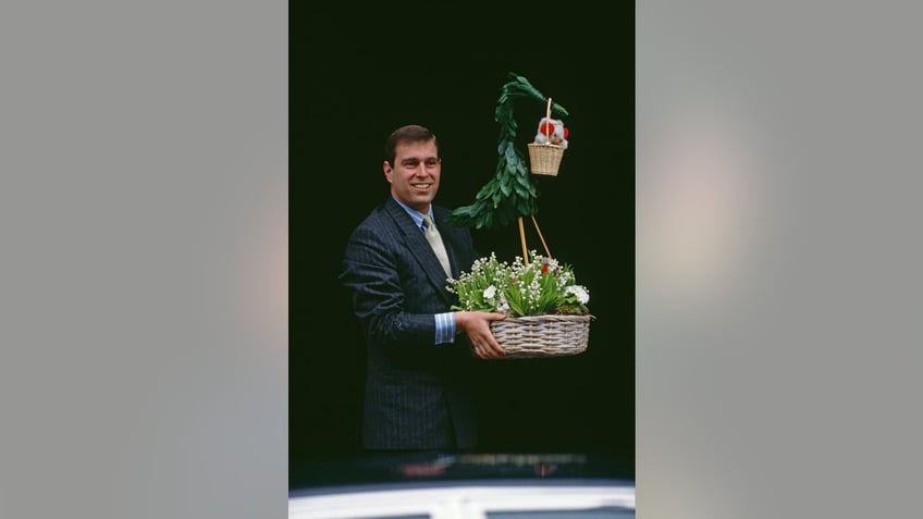 Prince Andrew holding a basket with plants and a teddy bear.