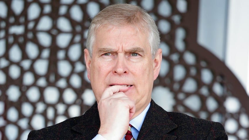 A close-up of Prince Andrew looking pensive in a dark suit.