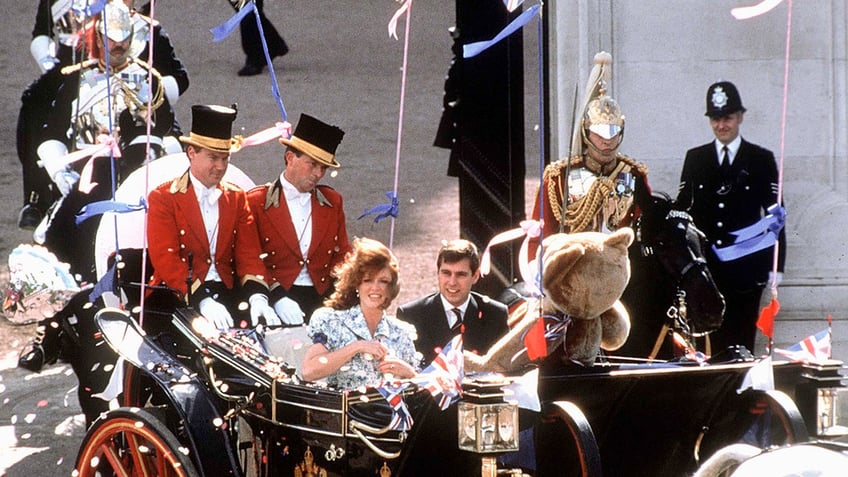 Prince Andrew and Sarah Ferguson in a royal carriage with a giant teddy bear.