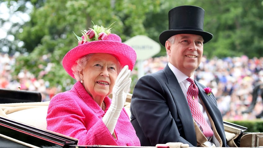 Queen Elizabeth waving in a hot pink suit next to her son Prince Andrew in a suit and top hat