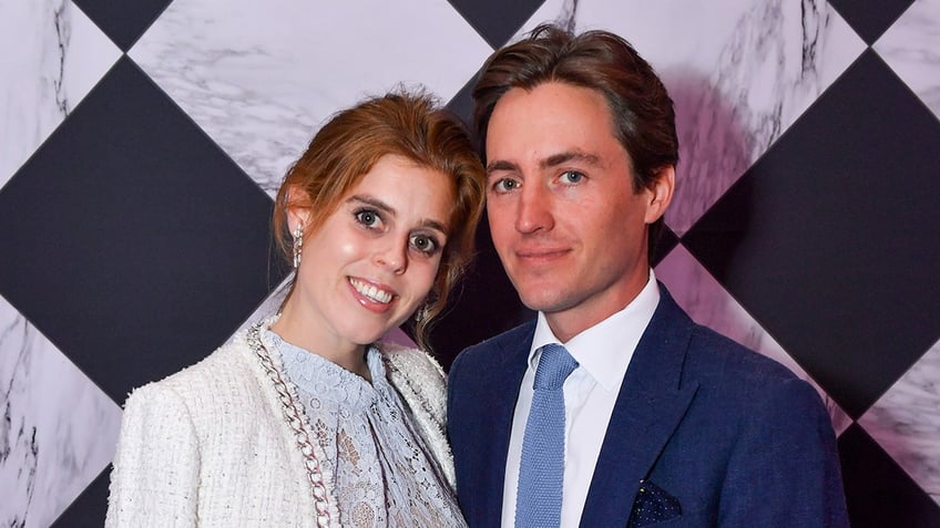 Princess Beatrice smiling and leaning into her husband.