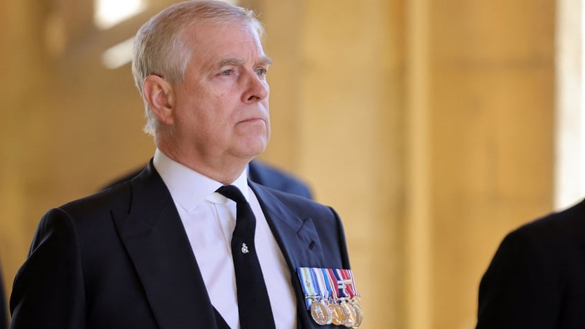 A close-up of Prince Andrew wearing a dark suit with medals.