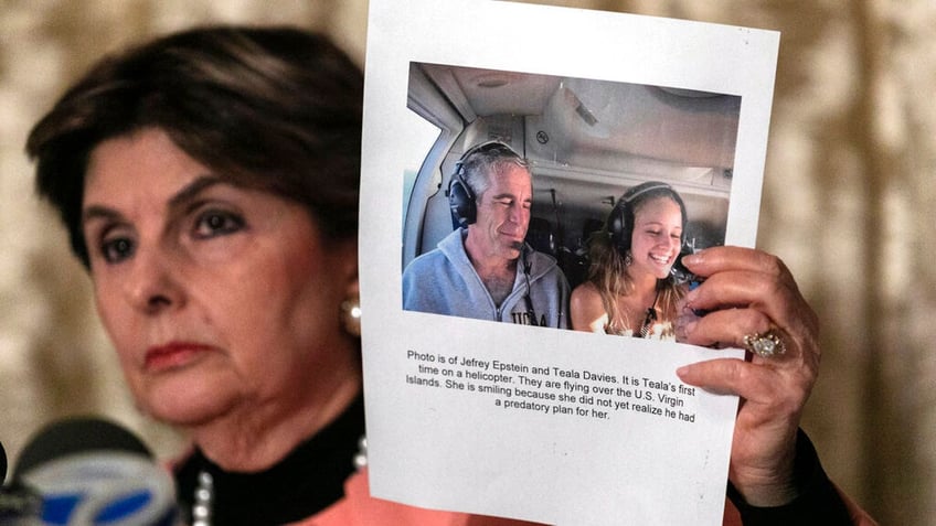 Gloria Allred holding a photo of Jeffrey Epstein and a young woman