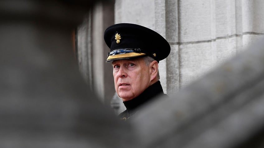 Prince Andrew wearing a suit and looking concerned.