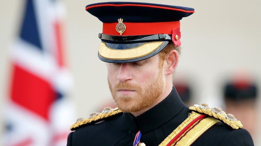 Prince Harry looking somber in a military suit.