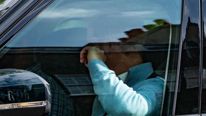 Prince Harry looking away inside his car