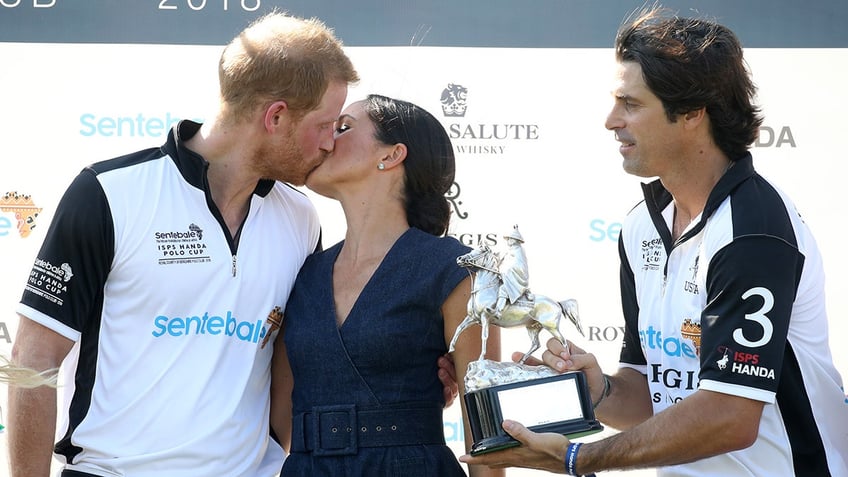 Nacho Figueras handing a medal to Prince Harry as he kisses Meghan Markle.