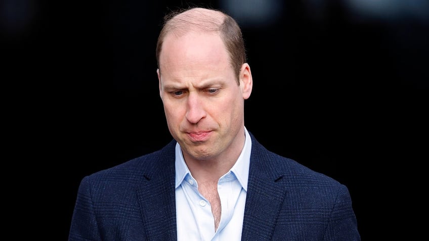 A close-up of Prince William looking upset in a blue blazer.