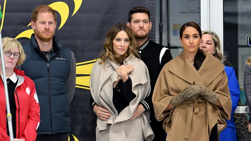 Prince Harry and Meghan Markle standing alongside Michael Buble and his wife