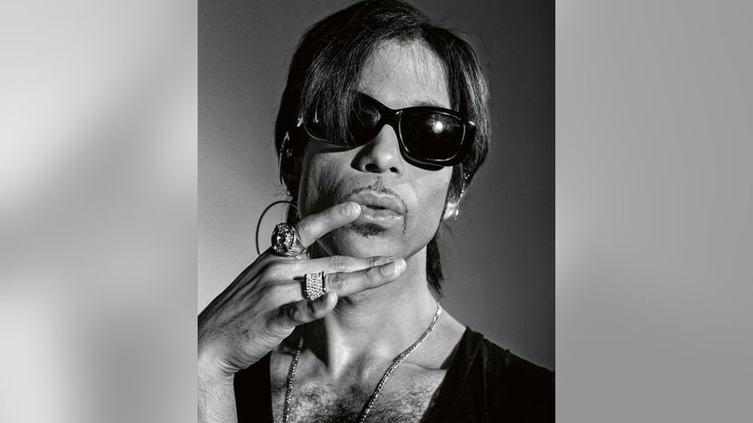 A close-up of Prince posing in dark glasses,