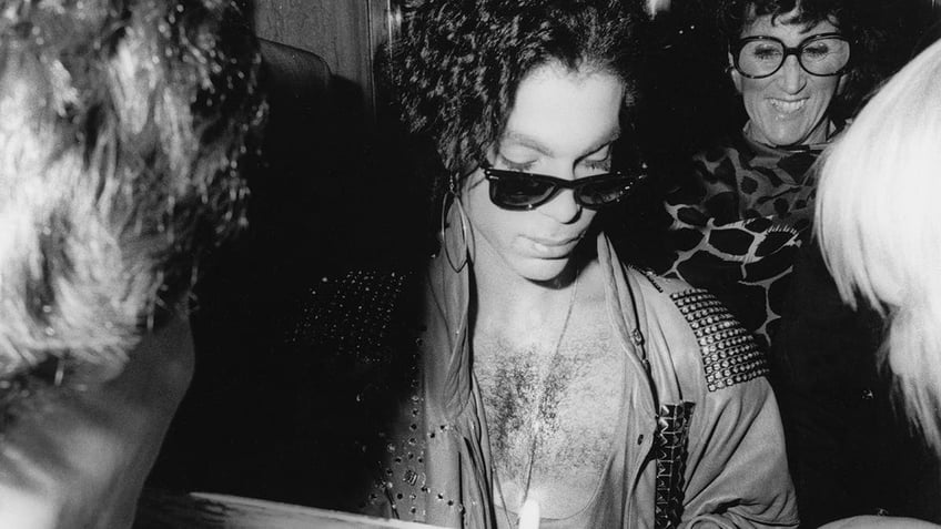 A close-up of Prince signing autographs.