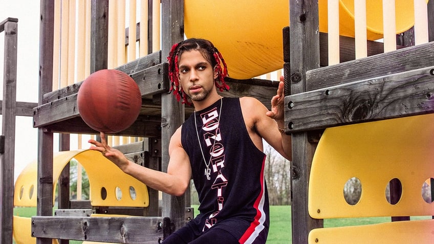 Prince in a black and red sleeveless outfit holding a basketball