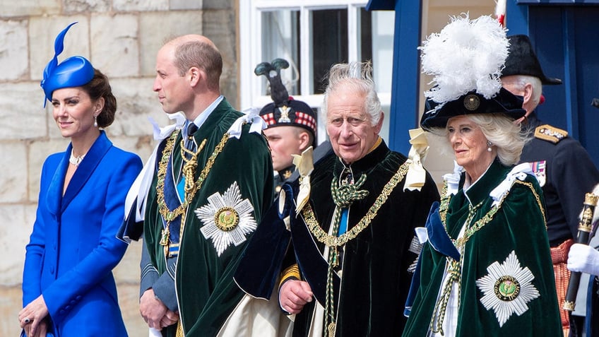 The British royal family wearing formal wear as they stand in a line looking serious.