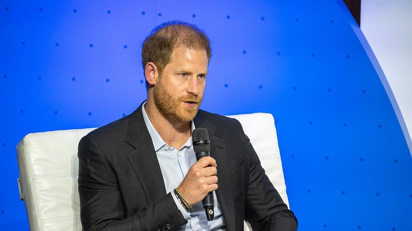 Prince Harry sitting and speaking into a microphone