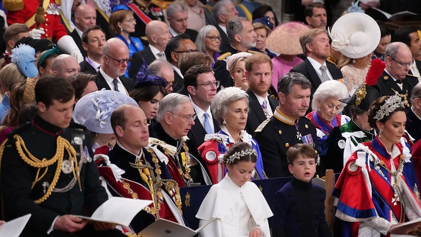 Prince Harry sitting in a crowd during his fathers coronation.