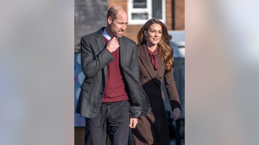 Kate Middleton in a brown suit walking alongside Prince William