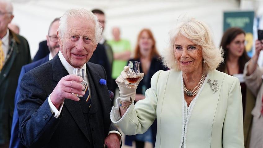 King Charles III and Queen Camilla toasting with a drink