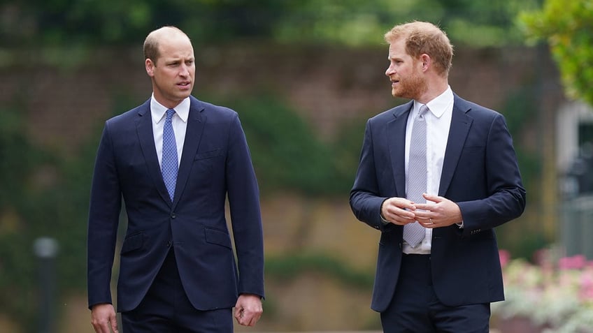 Prince Harry talking to his brother Prince William as he looks concerned.