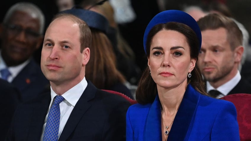 Prince William and Kate Middleton sitting next to each other and looking serious