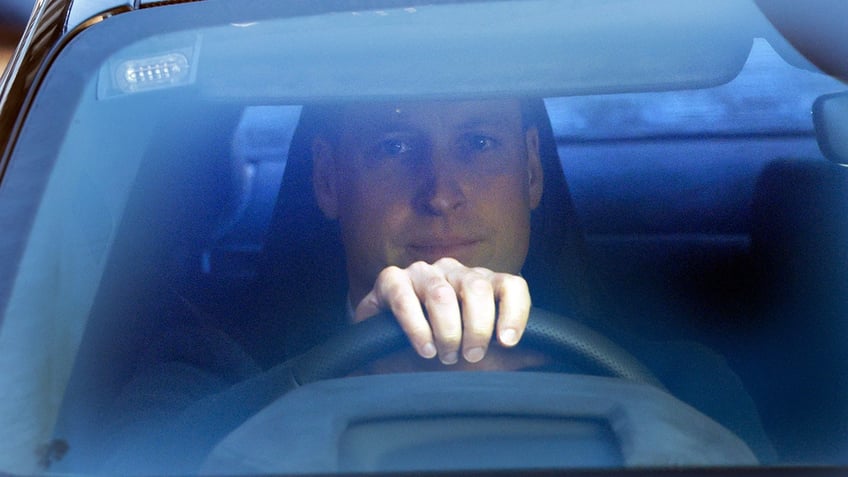 A close-up of Prince William driving his car