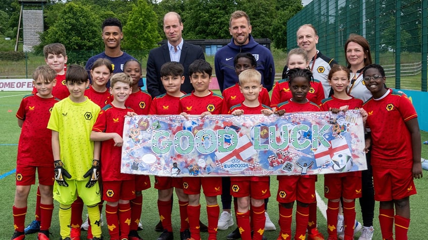 Prince William posing with a youth soccer team