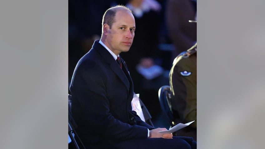 Prince William looking serious as he sits and stares at the camera