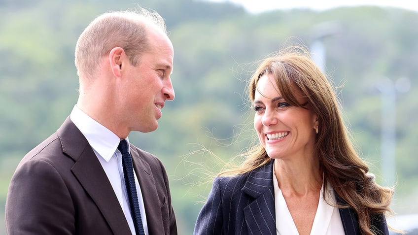 Prince William and Kate Middleton looking at each other and smiling.