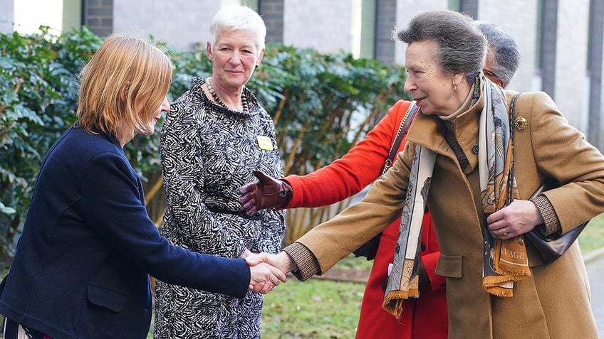 Princess Anne shakes a woman's hand.