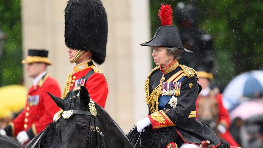 Princess Anne in formal uniform riding a horse.