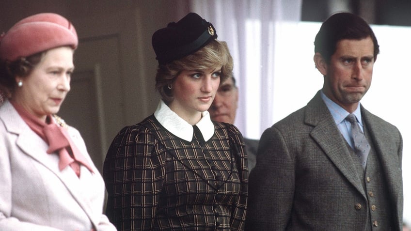 Queen Elizabeth, Princess Diana and Prince Charles standing next to each other and looking serious