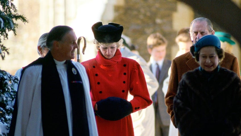 Princess Diana with her head down as she walks in front of the queen and a priest.