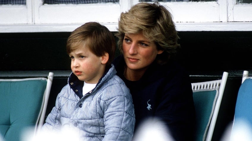 A young Prince William sitting on Princess Diana's lap at the polo.