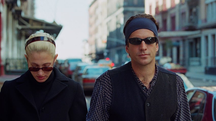 Carolyn Bessette-Kennedy and John F. Kennedy looking annoyed at a photographer.