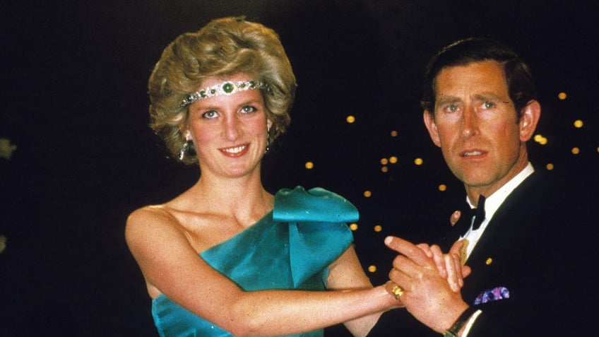 Princess Diana in a jeweled headband and an off-shoulder emerald dress dancing with Prince Charles.