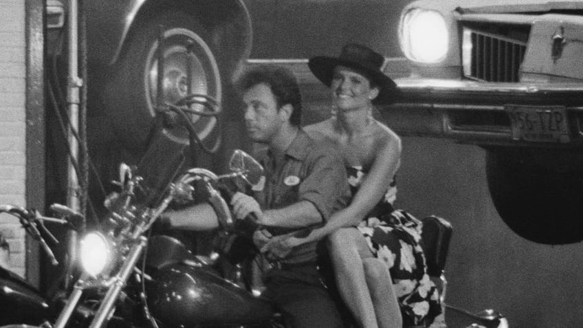 Billy Joel on a motorcycle with Christie Brinkley