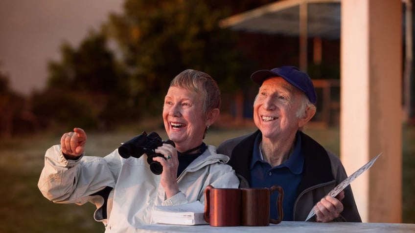 A couple sits outside at sunset