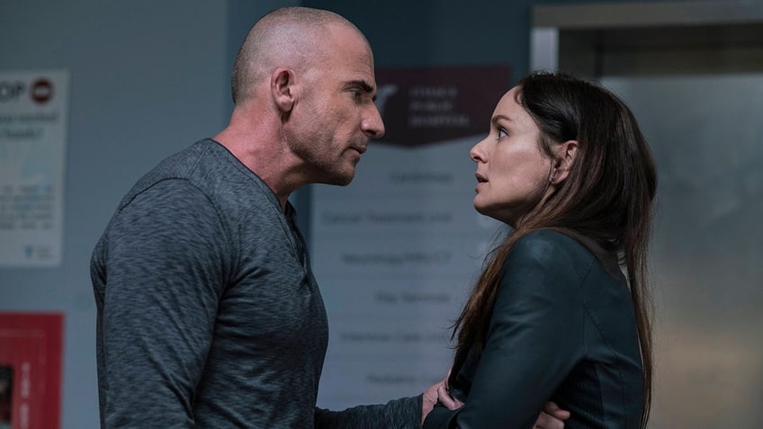 Dominic Purcell in a longsleeve looks serious across from Sarah Wayne Callies, whose arm he grabs, during an episode of "Prison Break"