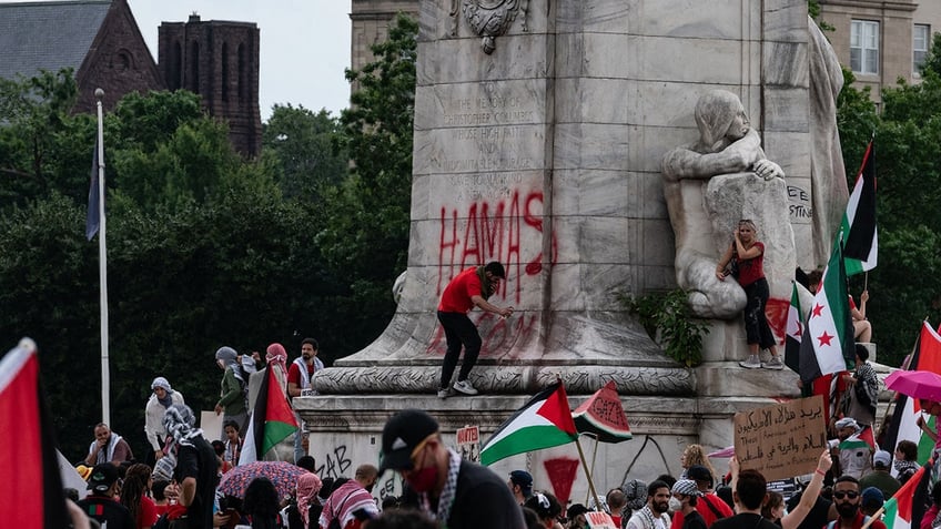 anti-israel demonstrators defacing Columbus monument in DC