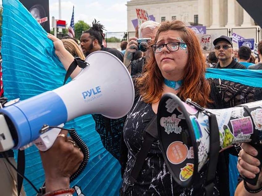 Lauren Handy, a member of Progressive Anti-Abortion Uprising, wears a cape as an anti-abor