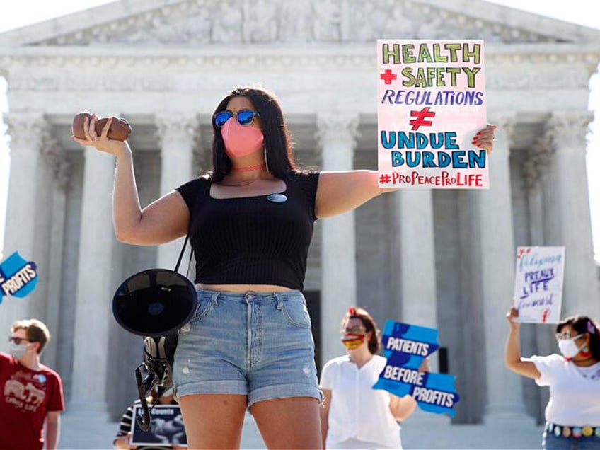 Terrisa Bukovinac, founder of Pro-Life San Francisco, holds a model of a fetus as she and other anti-abortion protesters wait outside the Supreme Court for a decision, Monday, June 29, 2020. The Supreme Court has struck down a Louisiana law regulating abortion clinics, reasserting a commitment to abortion rights over …