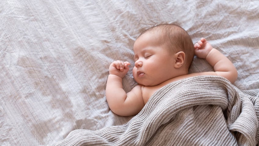 Newborn baby sleeping in bed